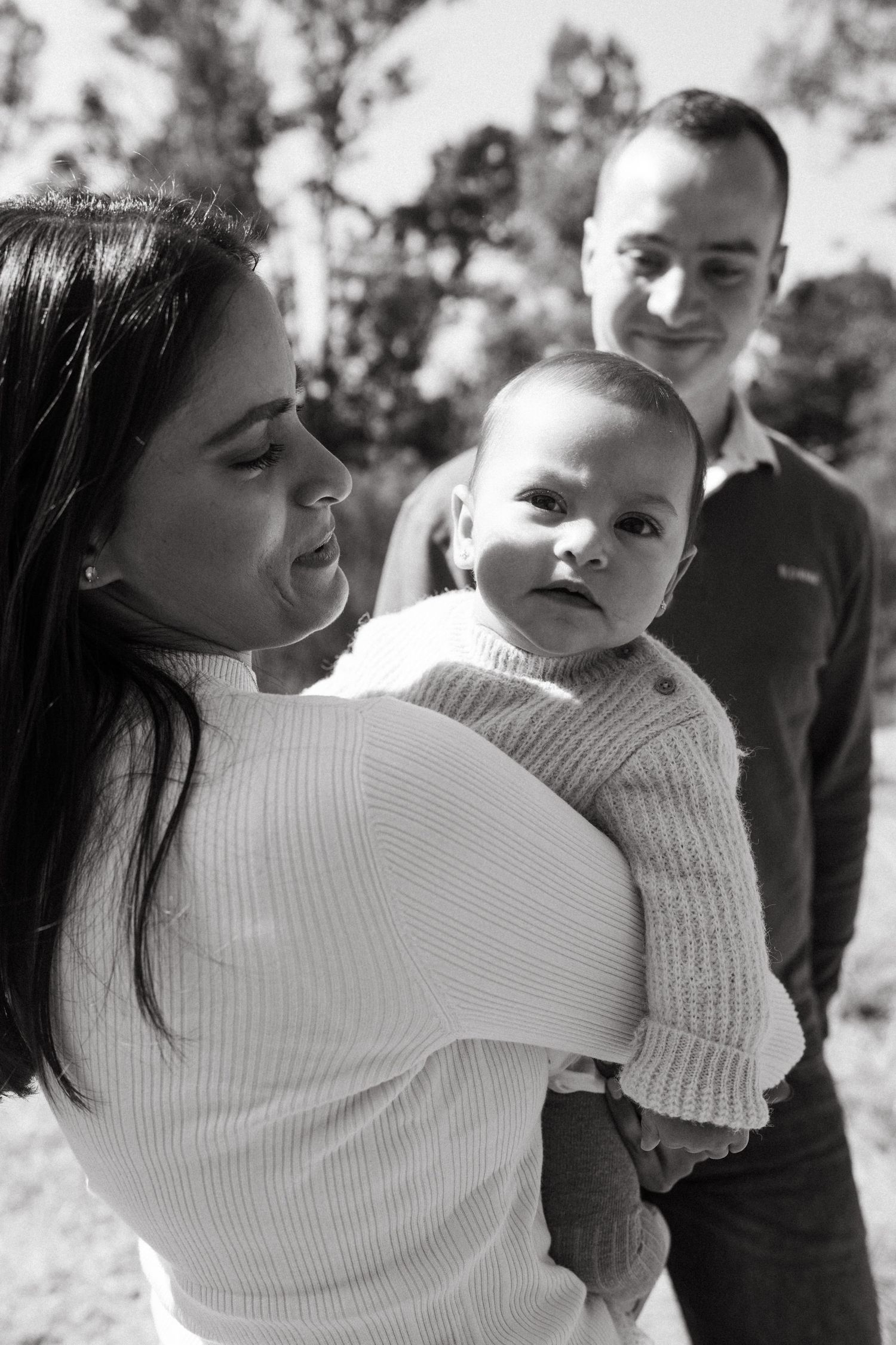 Intimate black and white portraits of family members embracing in natural outdoor setting.