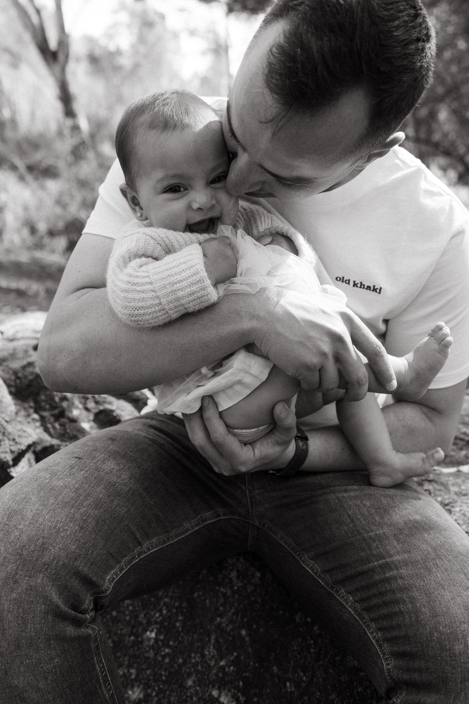 Black and white sequence showing tender family moments while sitting on rocks.
