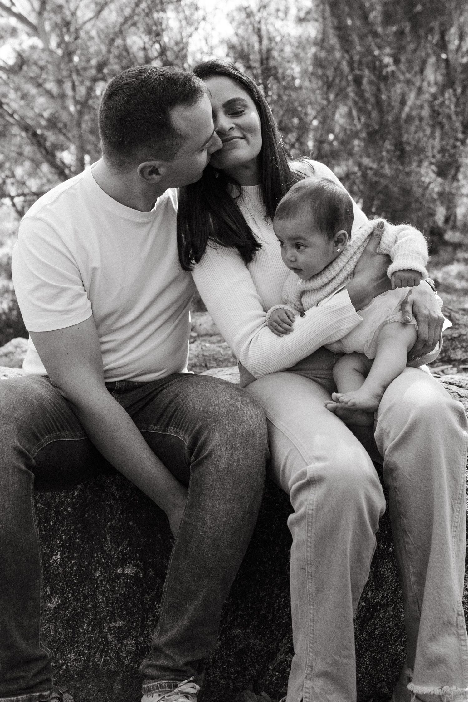 Series of intimate family moments captured in black and white on natural rocky terrain.