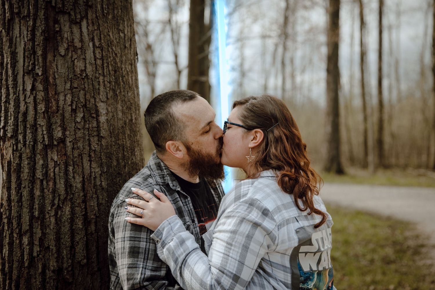 A couple shares romantic moments together while walking through a misty forest during autumn.