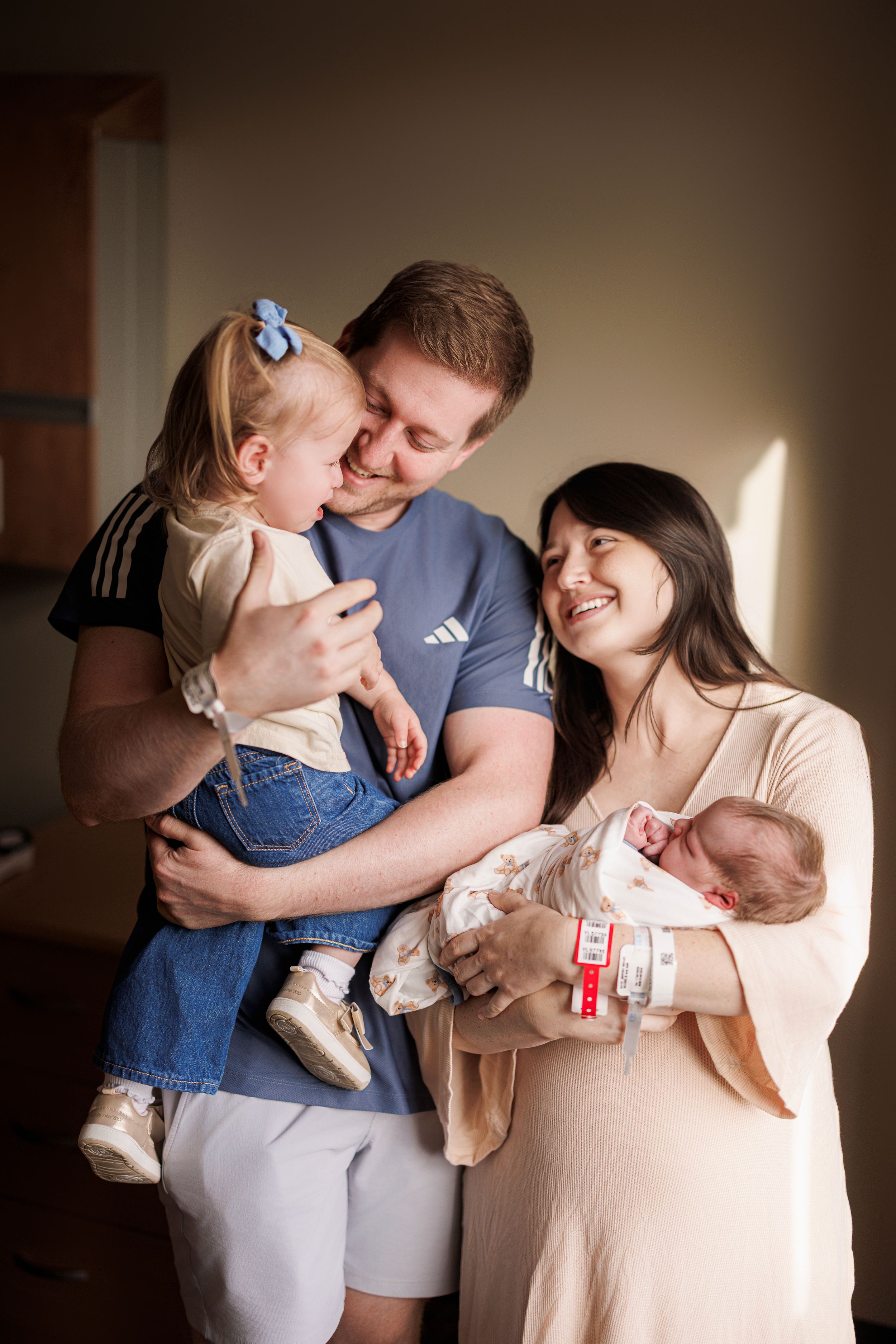 Series of intimate family portraits showing parents embracing their children in soft, natural light.
