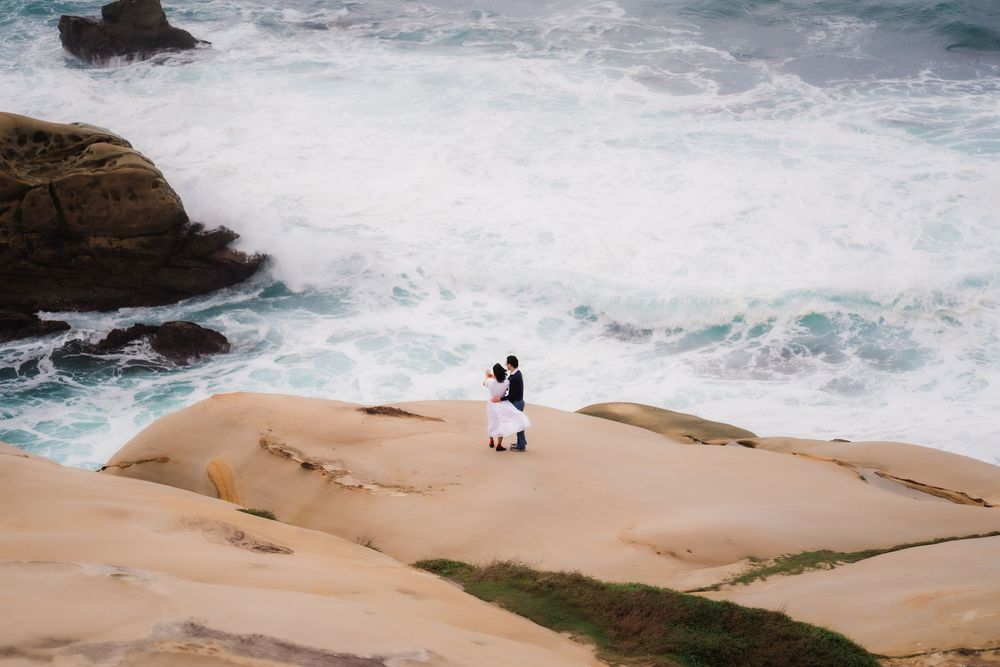 Dramatic waves crash against rocky coastal cliffs on a stormy day at the ocean's edge.