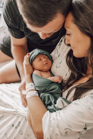 Parents lovingly embrace their newborn baby in a series of tender hospital moments after birth.