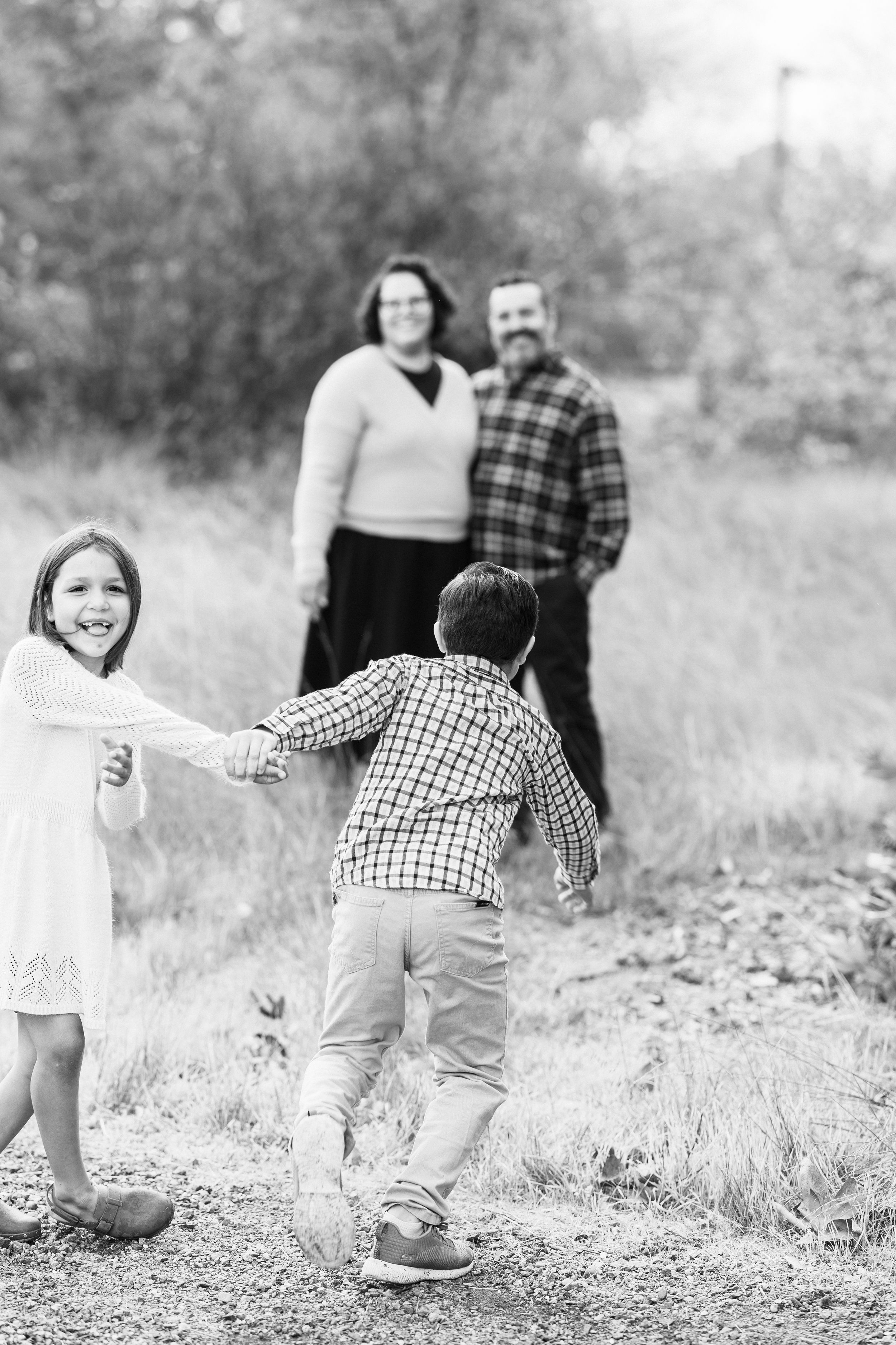 Black and white photo of playful children running and having fun outdoors.