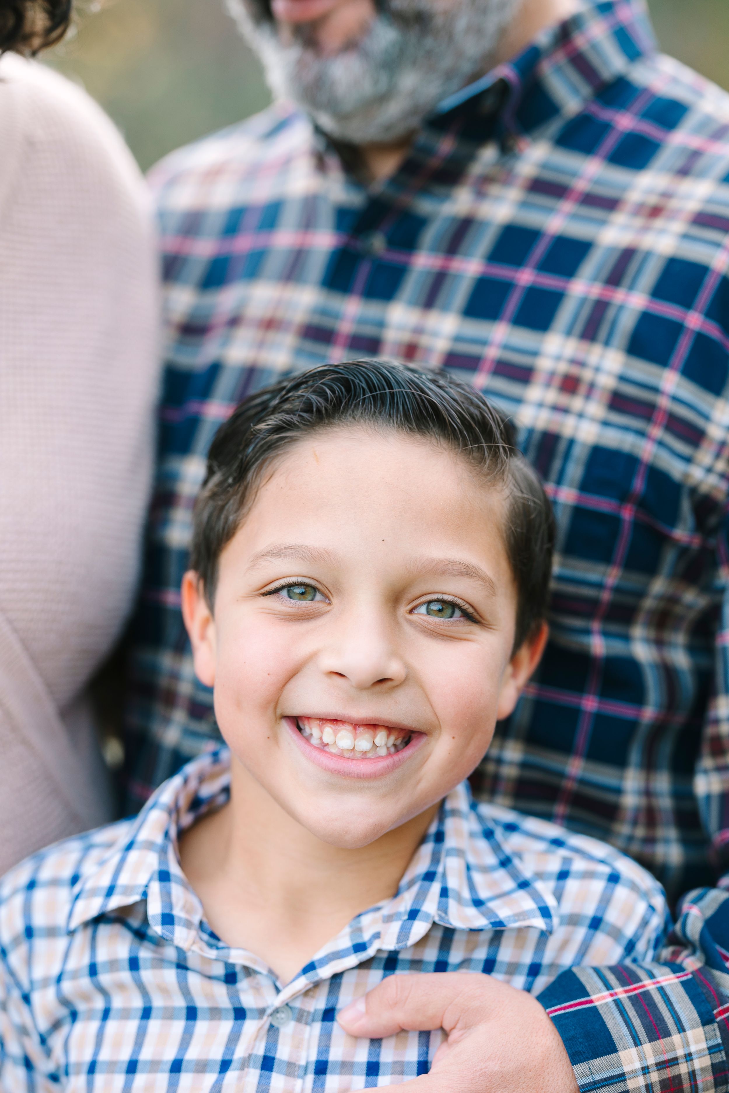 Close-up sequence of a smiling child wearing a plaid shirt.