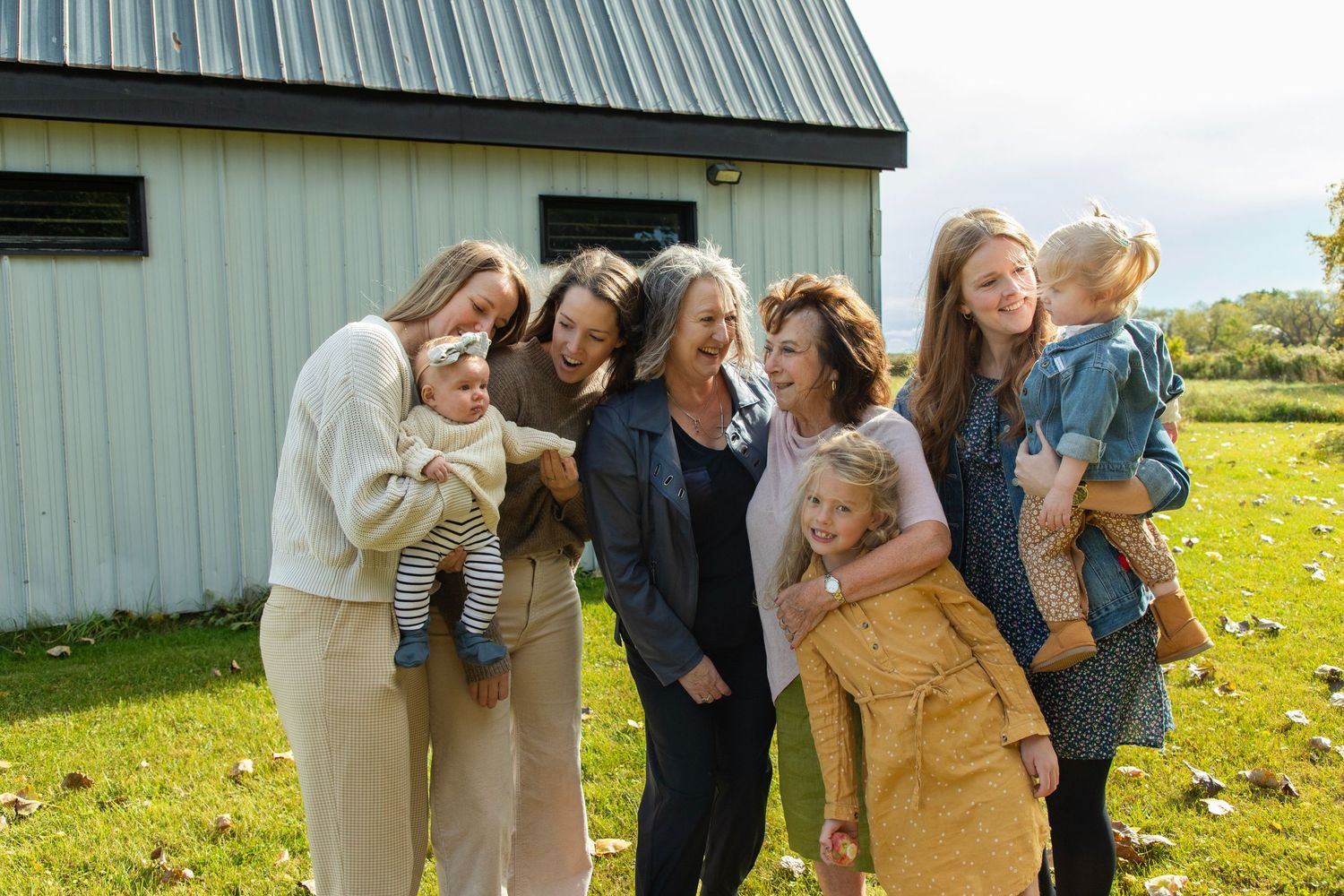 An extended family photo session with all 4 generations of women and children looking at one another