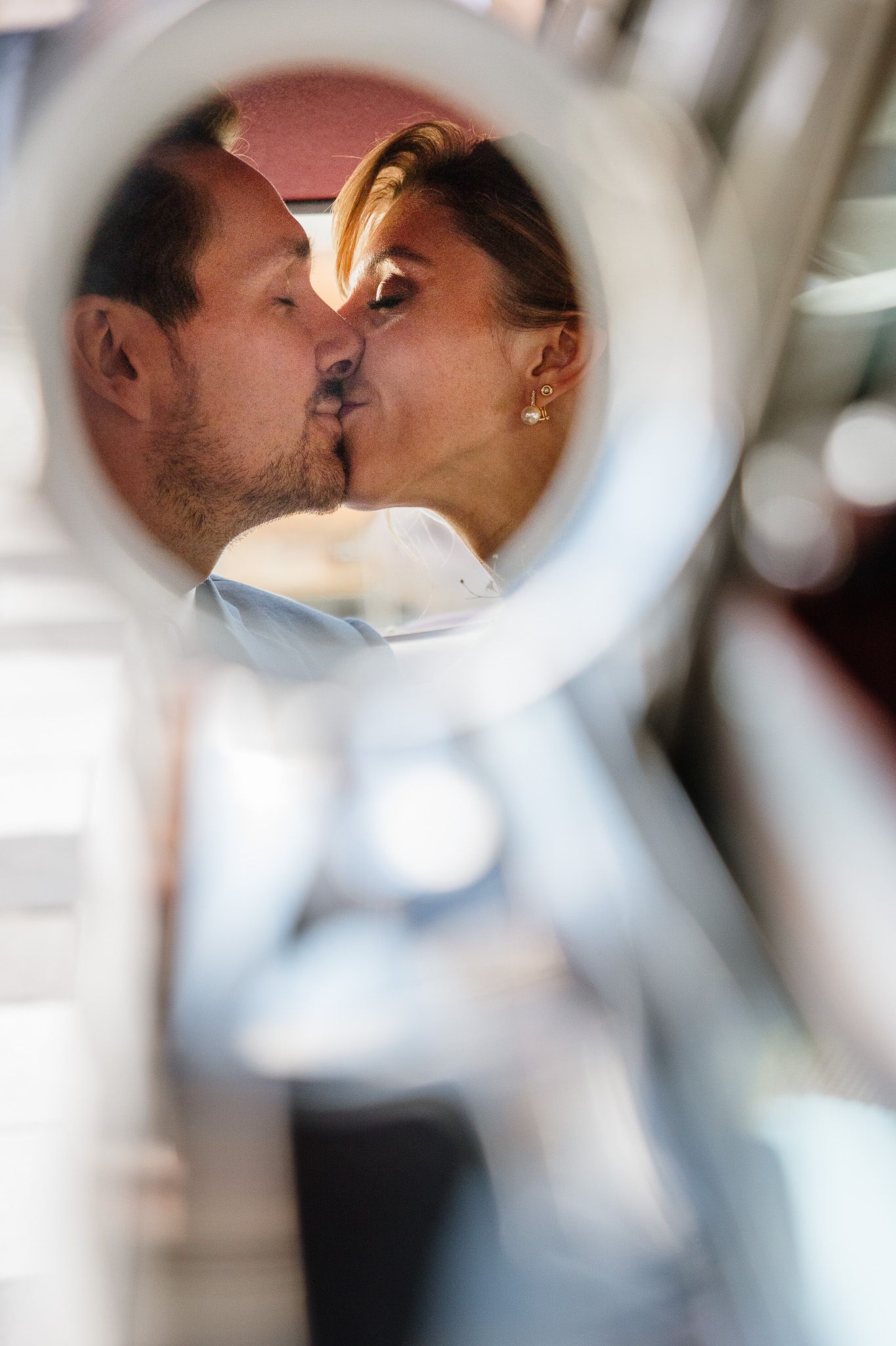 Photographe mariage Lille : photo des maries dans le retroviseur de leur voiture pour se rendre au chateau du biez pour la reception