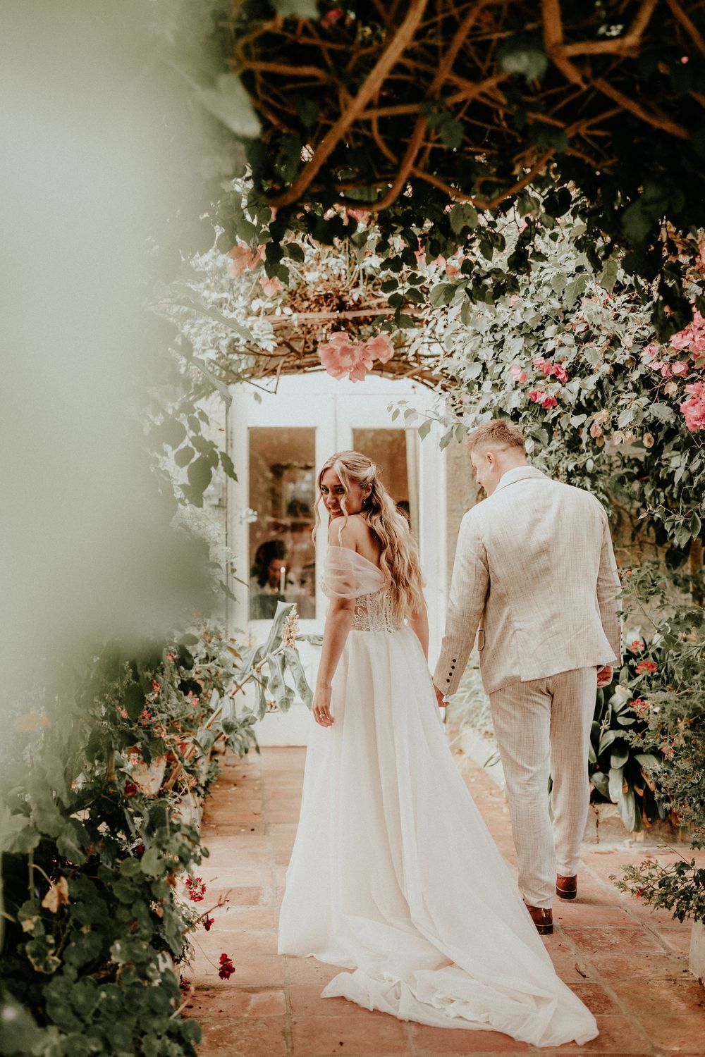 A dreamy wedding photoshoot in a garden setting with white flowers and soft lighting. Cornwall wedding photographer