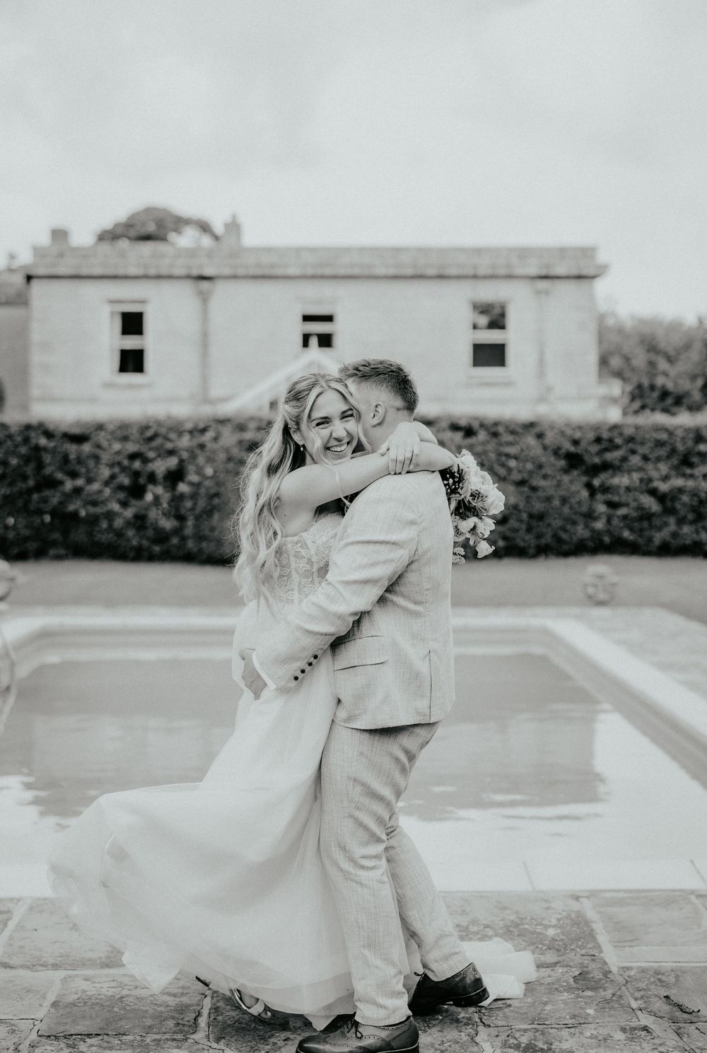 A couple dances and twirls together outdoors in black and white photography. Cornwall wedding photographer