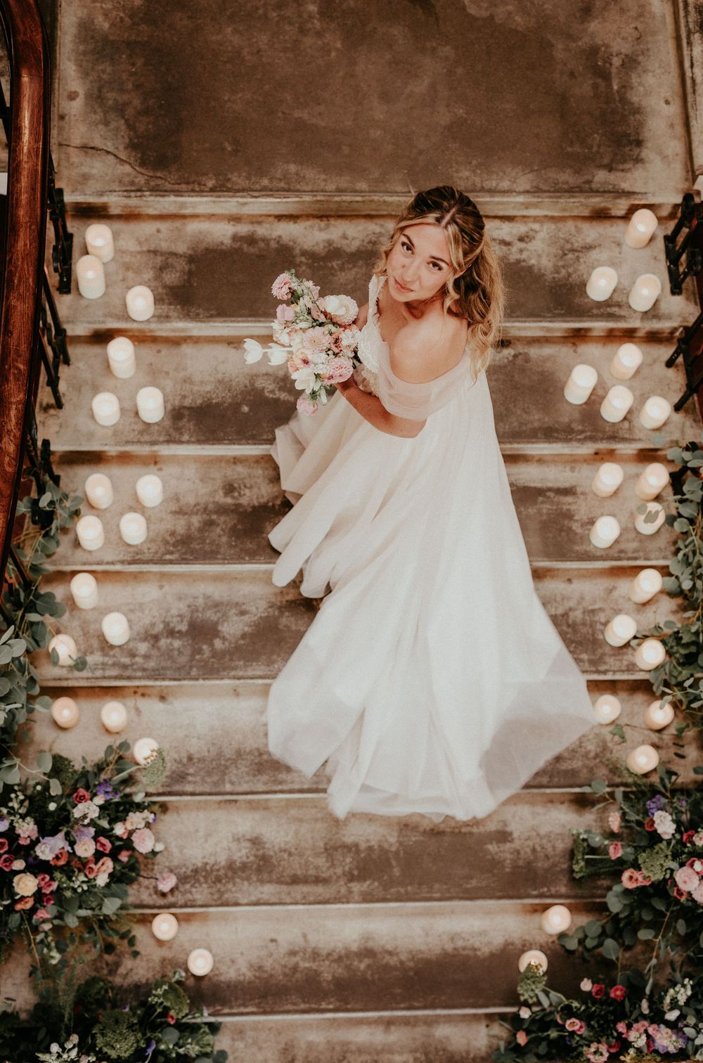 A whimsical wedding scene with string lights and floral decor against a rustic wooden wall. Cornwall wedding photographer