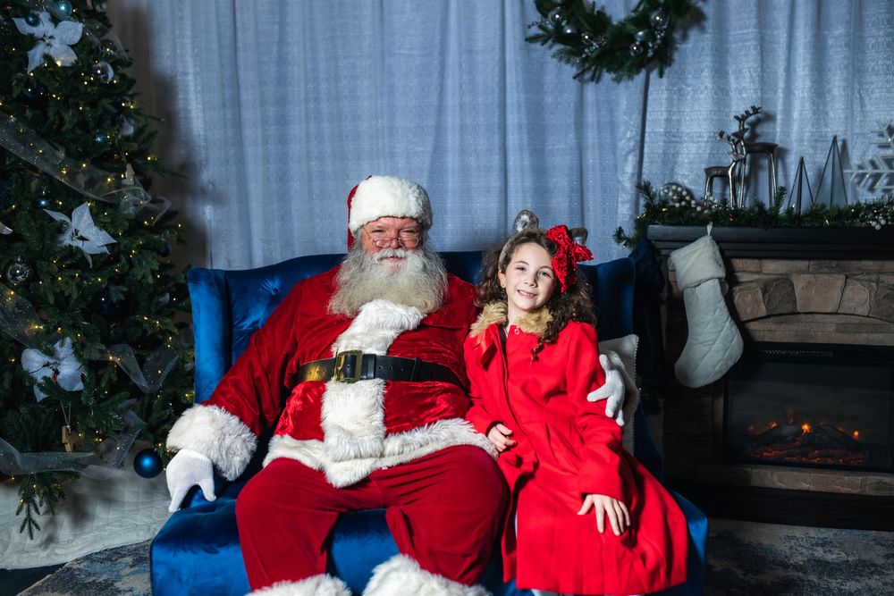 Children visit with Santa Claus during a festive holiday photo session with Christmas decorations and lights.