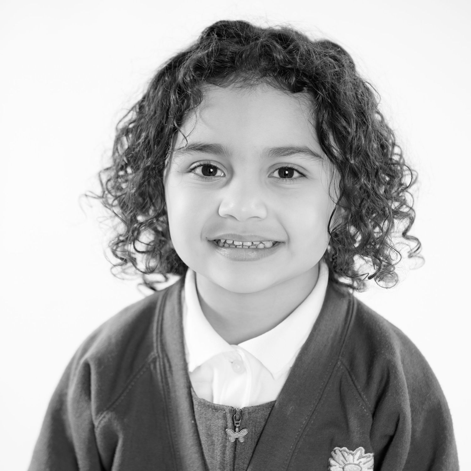 Photo of a young girl showing an option in black and white. A school studio photo taken on a white background.