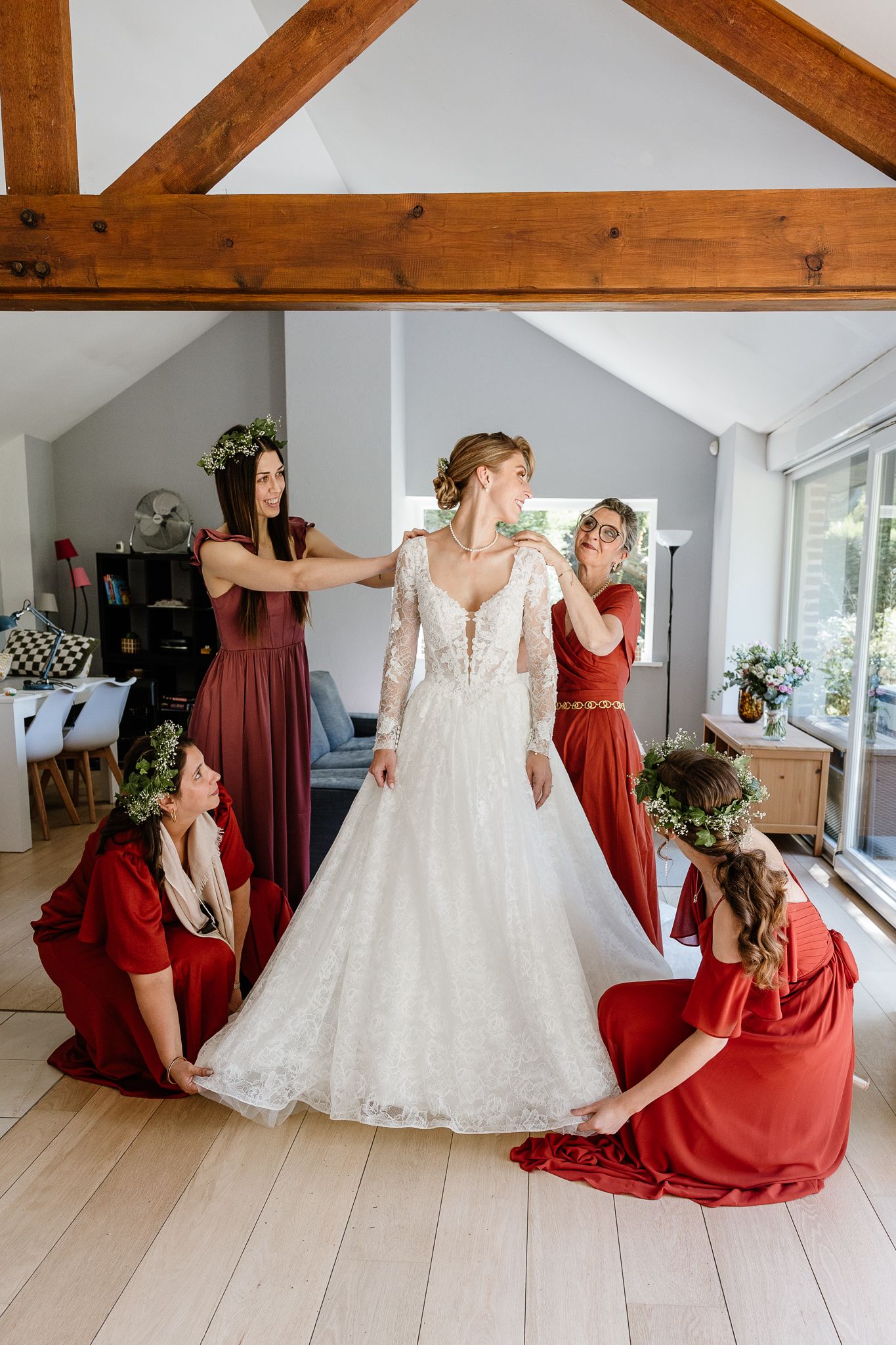 Preparatifs de la mariee, les temoins, demoiselles d'honneur et la maman ajustent la robe pendant un reportage photo de mariage a Lille