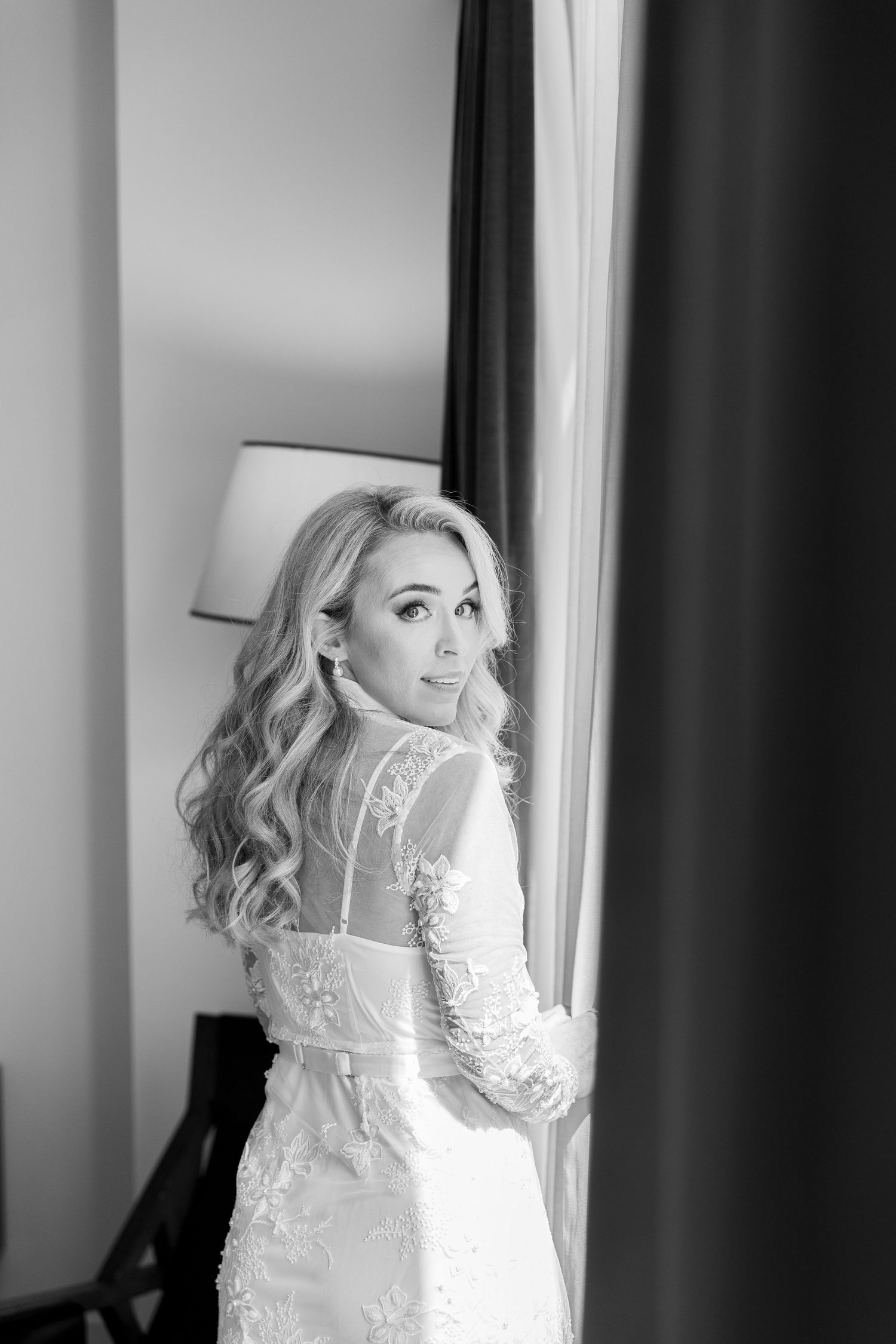 A bride in a white lace wedding dress poses elegantly in a series of black and white portraits by a window. NASHVILLE WEDDING PHOTOGRAPHER