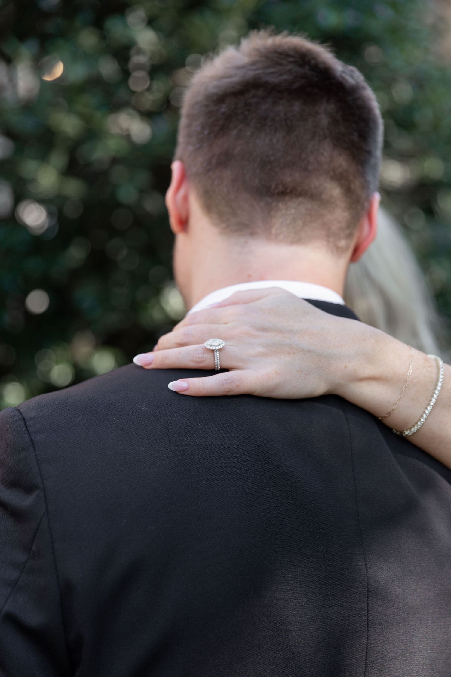 Close-up view of hands embracing at a wedding with a sparkling engagement ring and bracelet visible.NASHVILLE WEDDING PHOTOGRAPHER