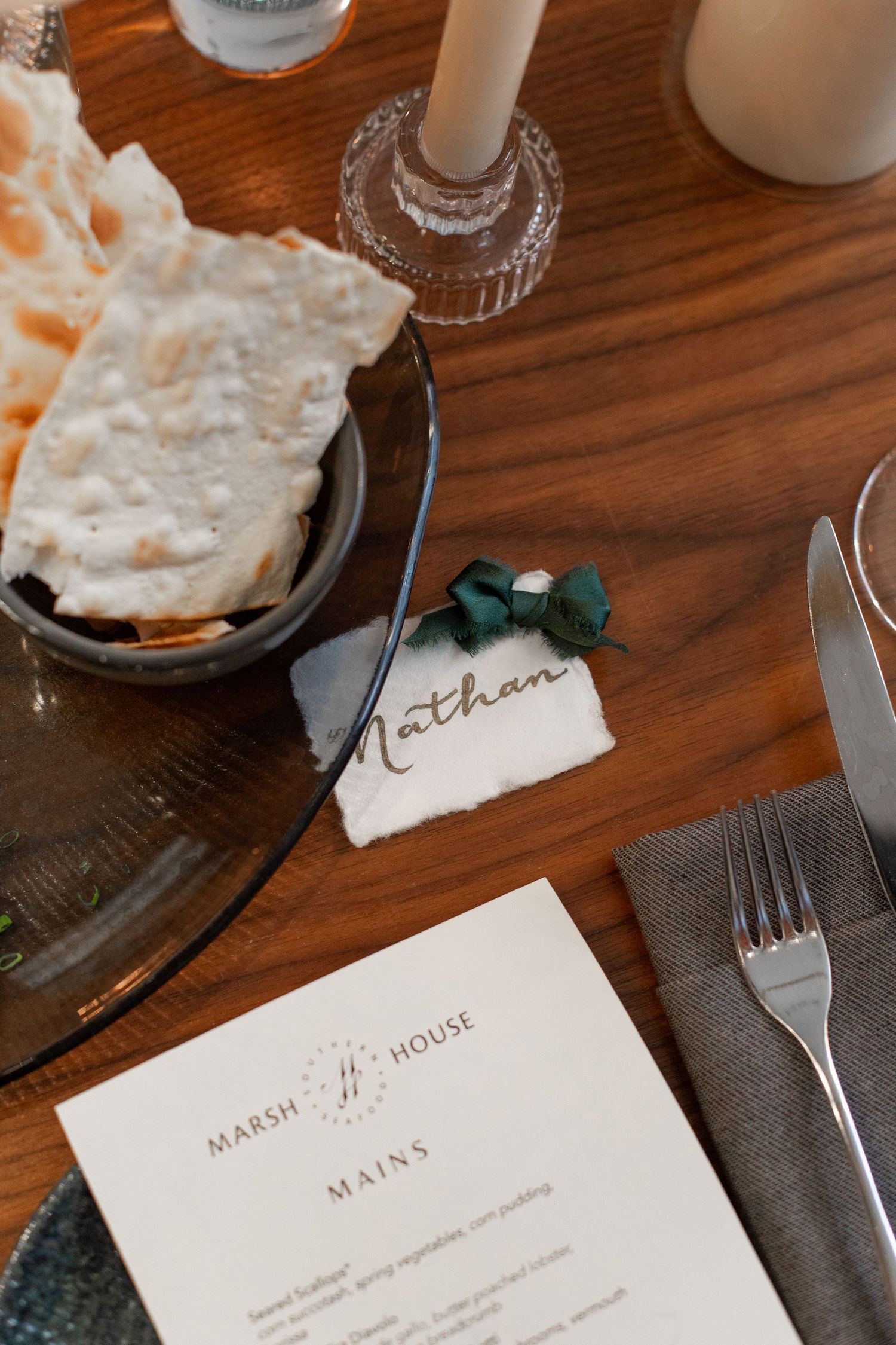 Wedding place settings with menu cards and elegant table decor on a dark wooden surface. NASHVILLE WEDDING PHOTOGRAPHER