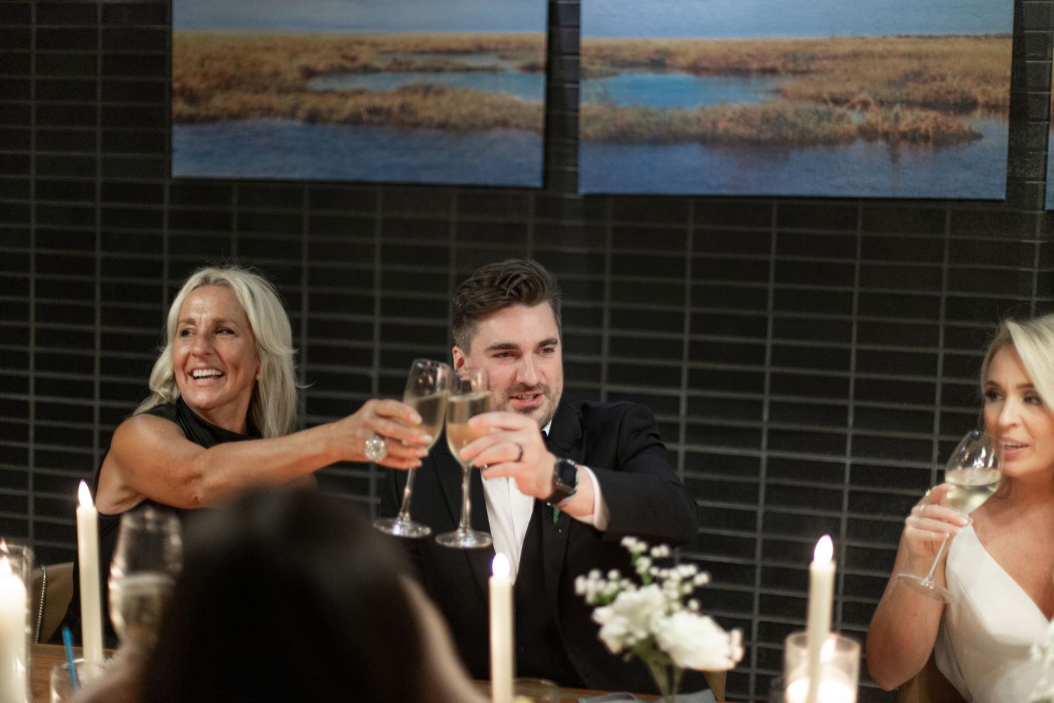Wedding guests raise champagne glasses in celebration during an outdoor reception toast.NASHVILLE WEDDING PHOTOGRAPHER