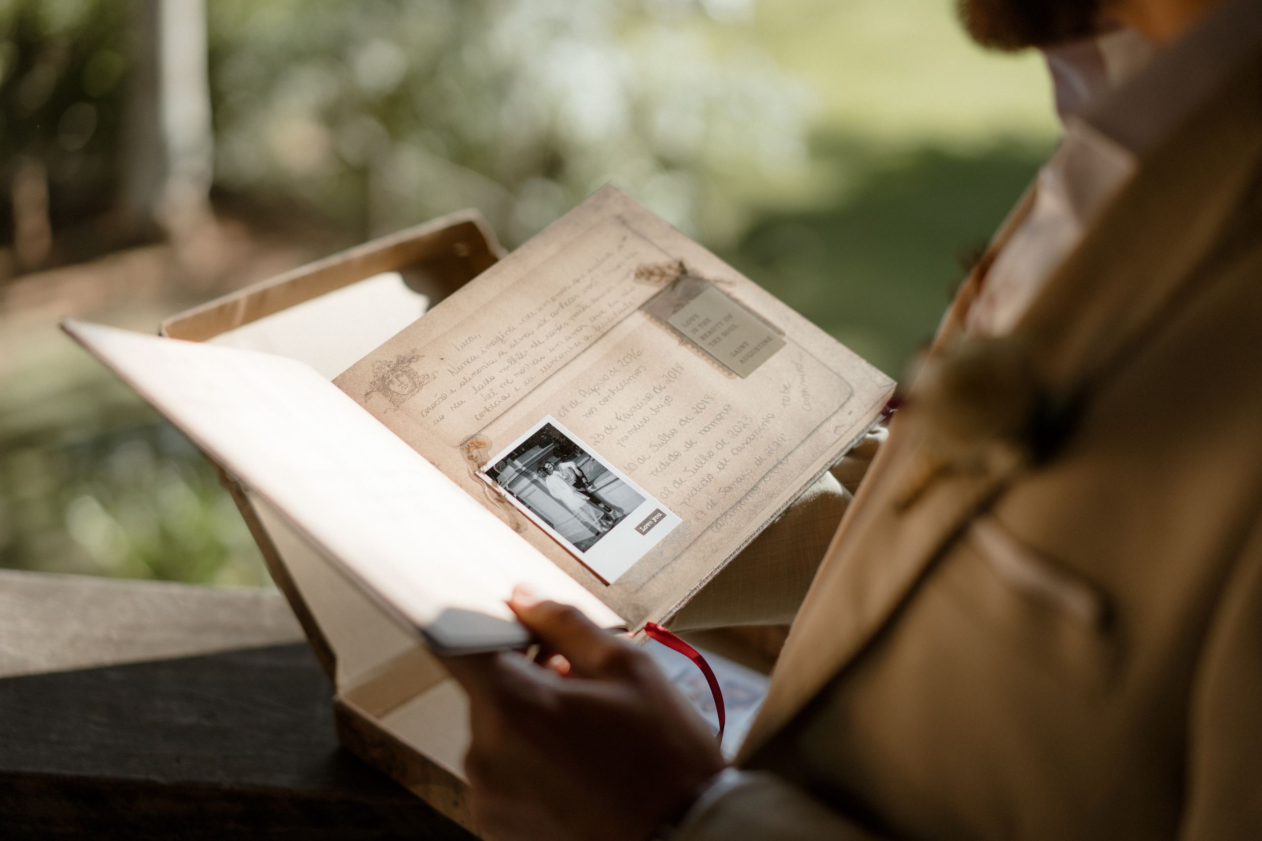 Close-up shot of hands holding open a vintage book or photo album.