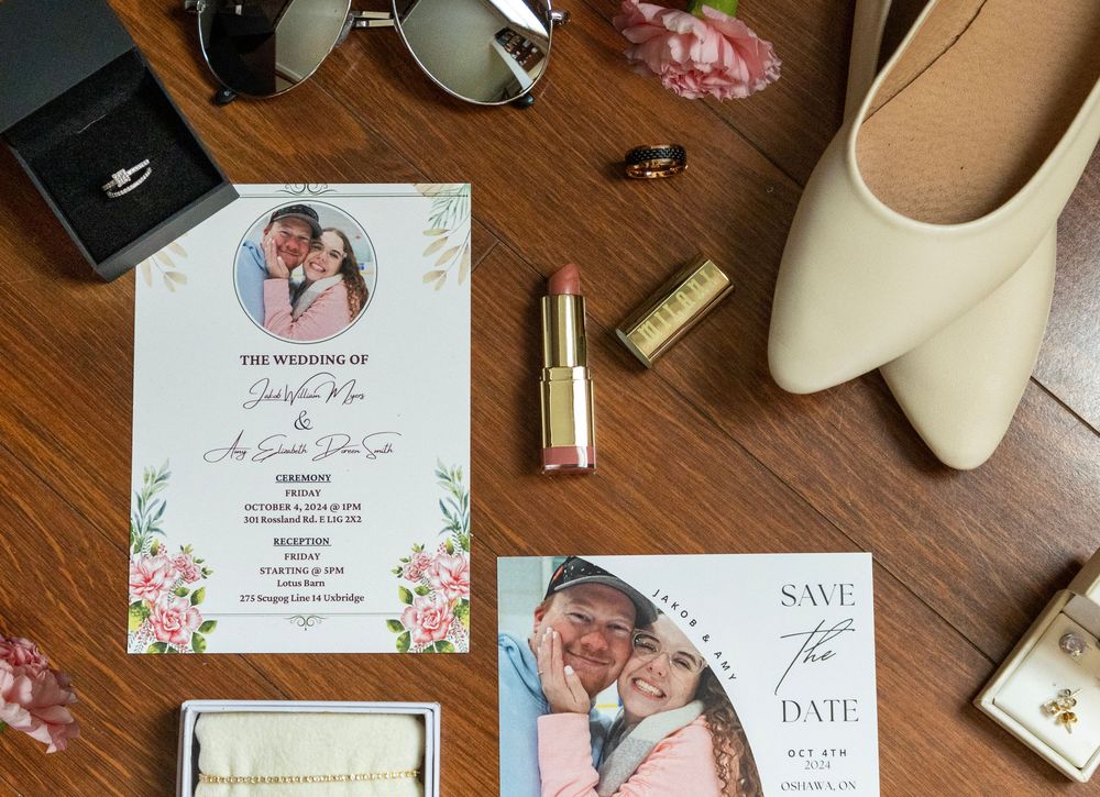 flatlay of wedding details including but not limited to, invitation, lipstick, rings and shoes