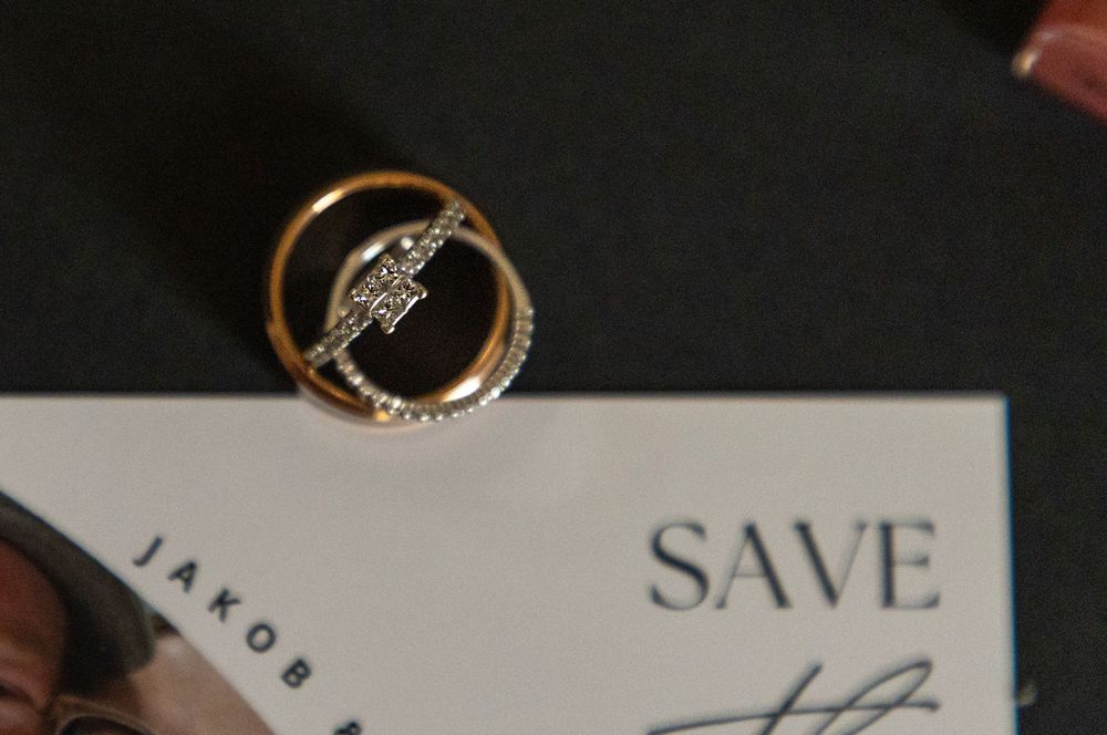 detail shot of bride and grooms rings on a save the date card