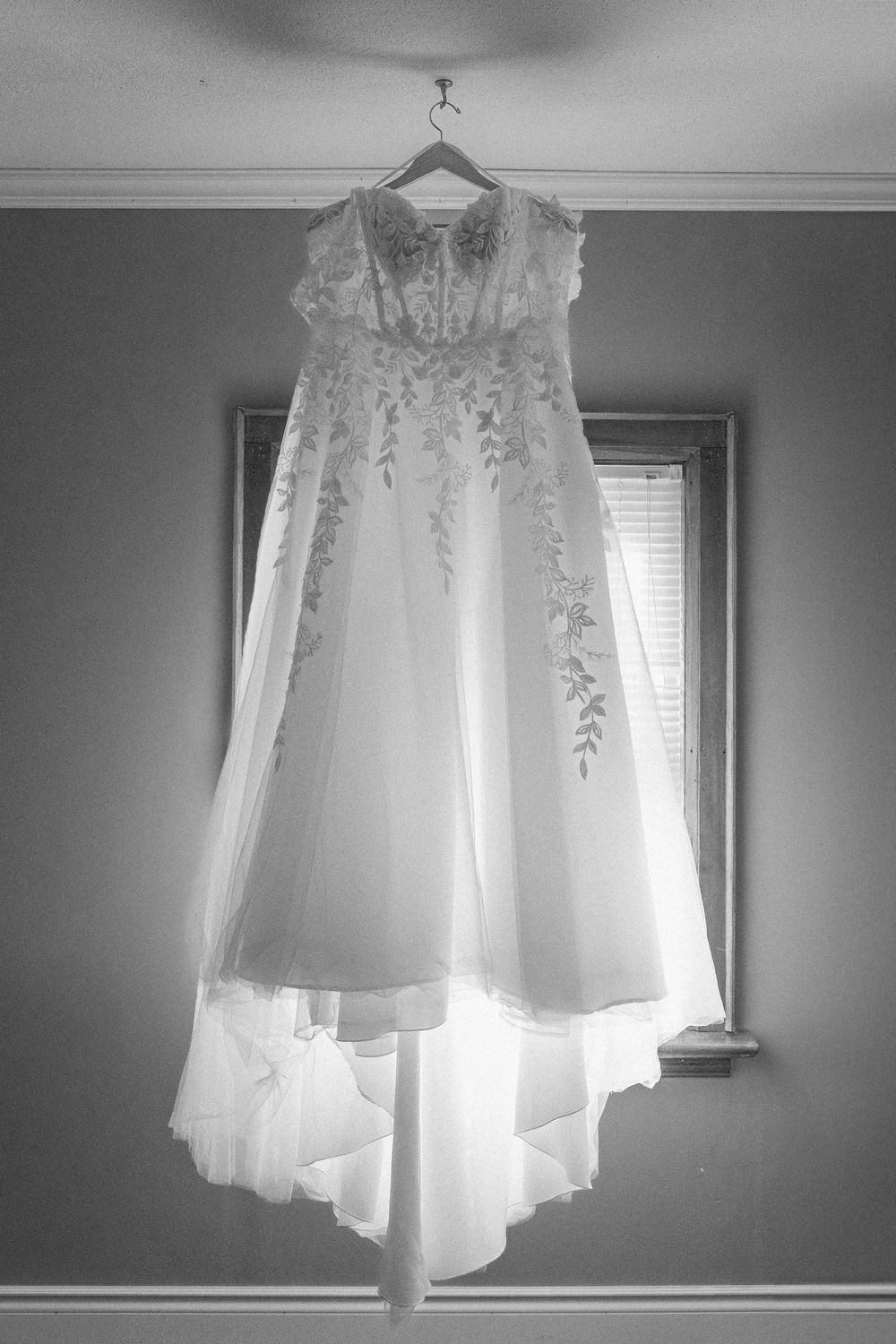 wedding dress in black and white hung up in a window
