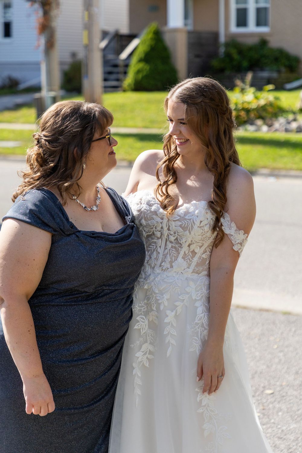 mother and bride admiring each other outdoors