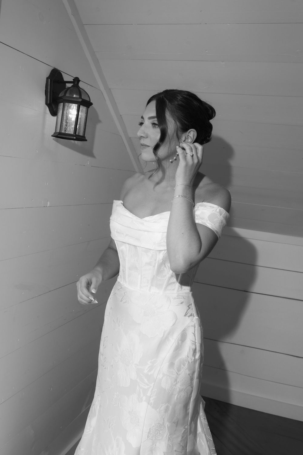 A figure in a white wedding dress is shown in a series of black and white photographs against a light wall.