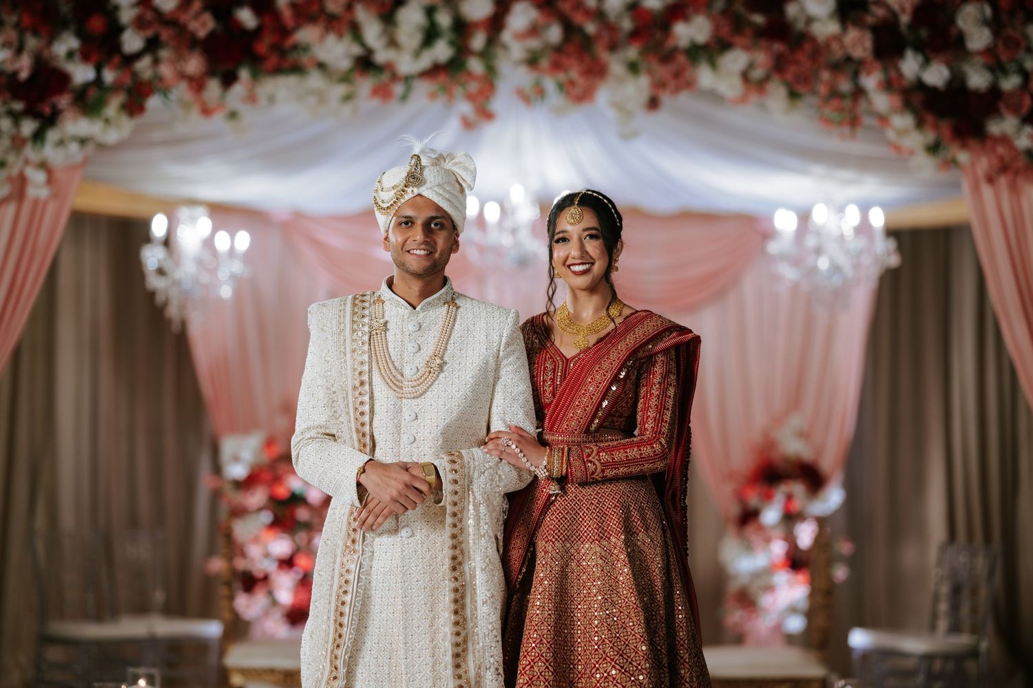 Elegant South Asian wedding at Downtown Marriott Philadelphia, with the couple glowing beneath a stunning floral mandap.