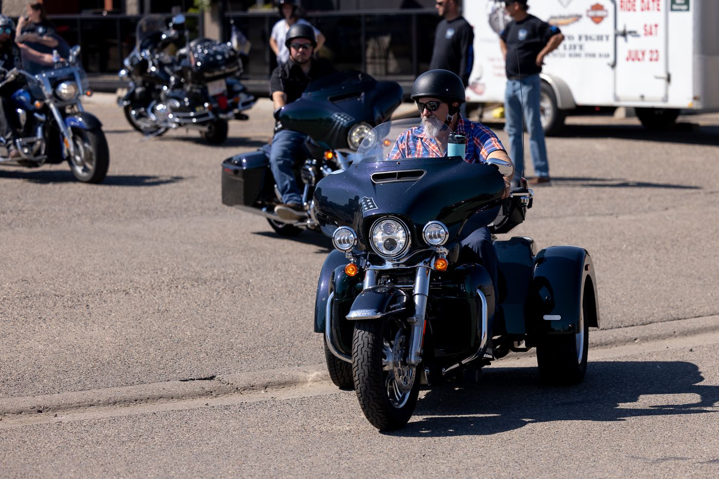 Motorcycles lined up at an outdoor gathering as riders gather for a group event or rally.