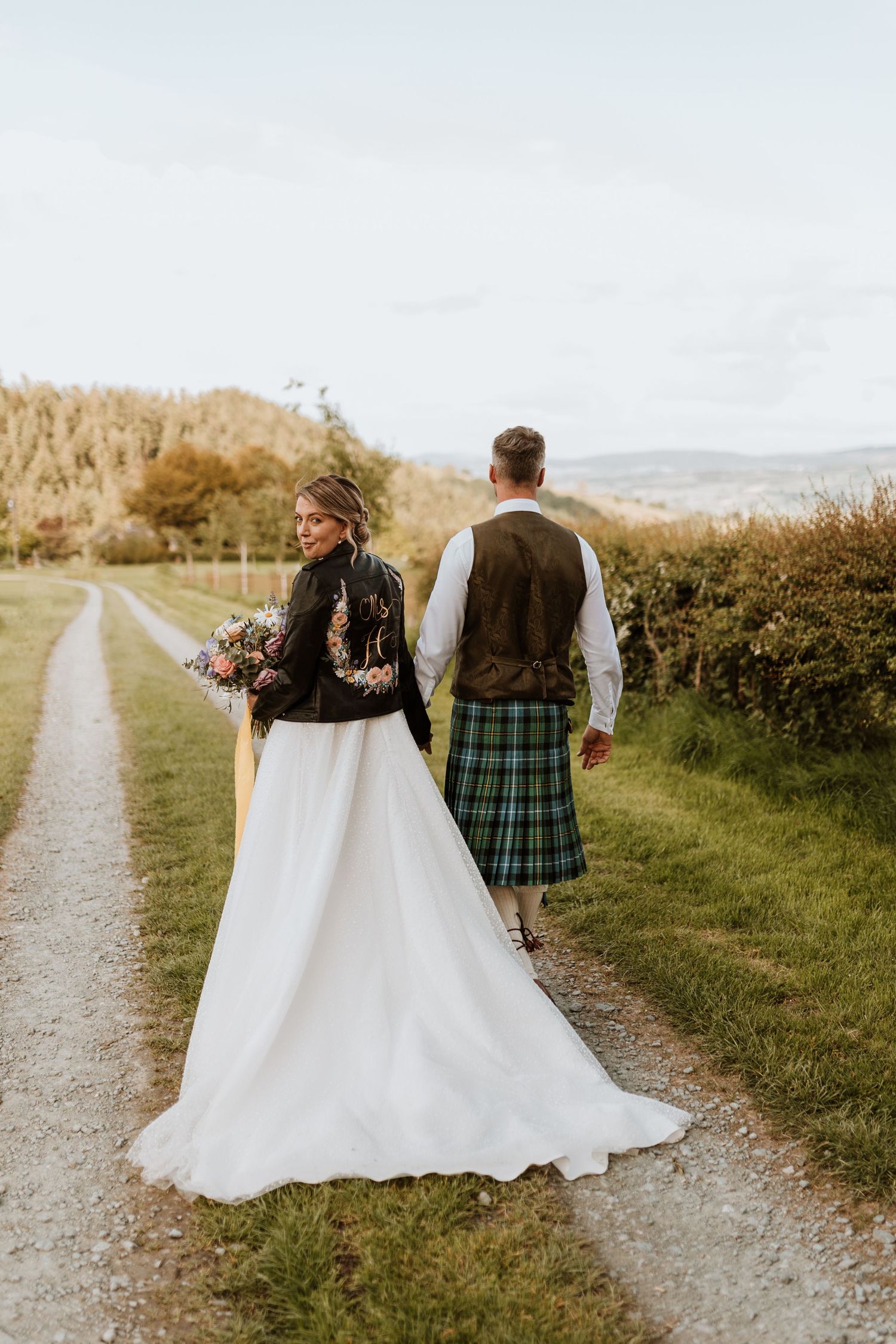 A couple in wedding attire with Scottish kilt walking down a countryside path in three sequential candid shots.