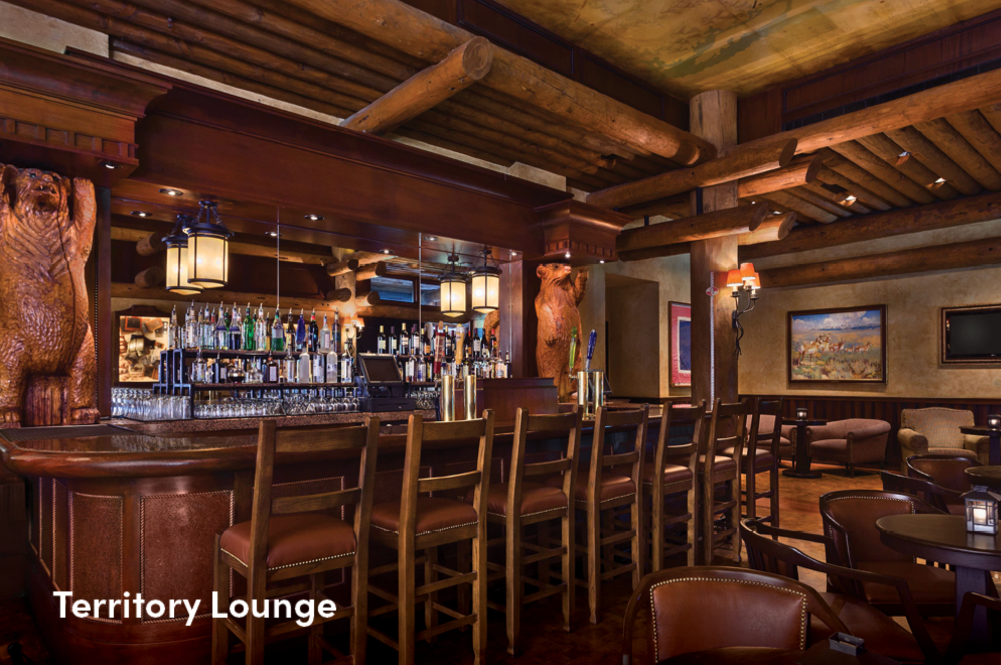 Rustic wooden beamed interior of Territory Lounge bar featuring warm lighting and cozy seating areas.