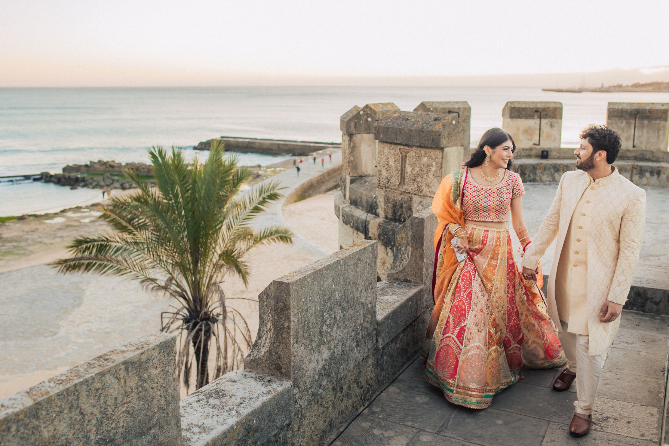Indian wedding at Forte da Cruz with vibrant colors, joyful moments, and stylish details by Portugal wedding photographer Regina.