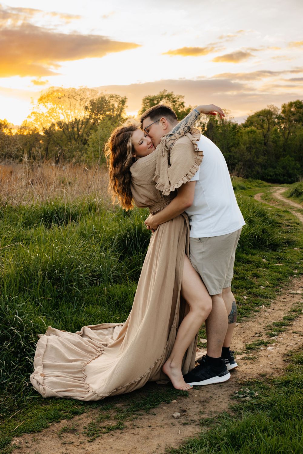 Romantic sunset photoshoot in a grassy field with flowing dress and dramatic poses.