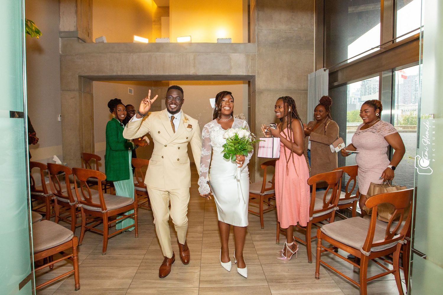 Wedding celebration scene in a church aisle with guests in pink and beige attire.