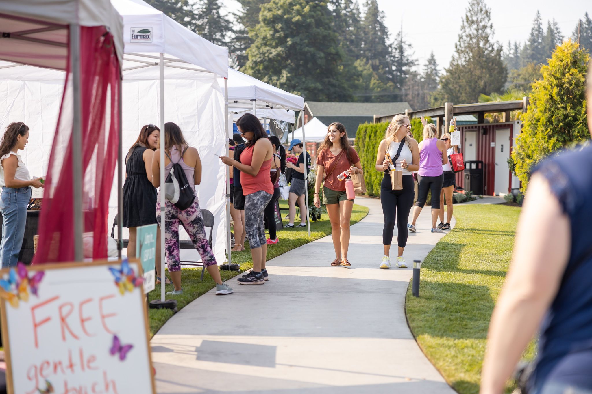 eastside women's day out wellness event in Redmond, WA outdoors vendors and attendees walking down path