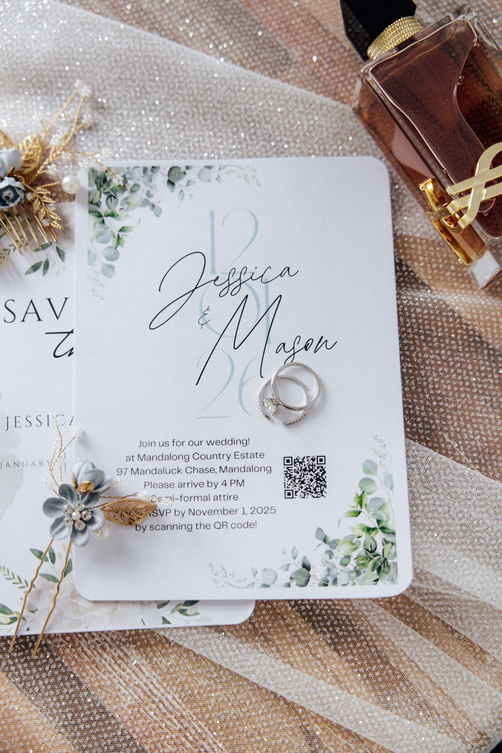 Elegant wedding invitation cards with floral designs and QR codes displayed on textured fabric.