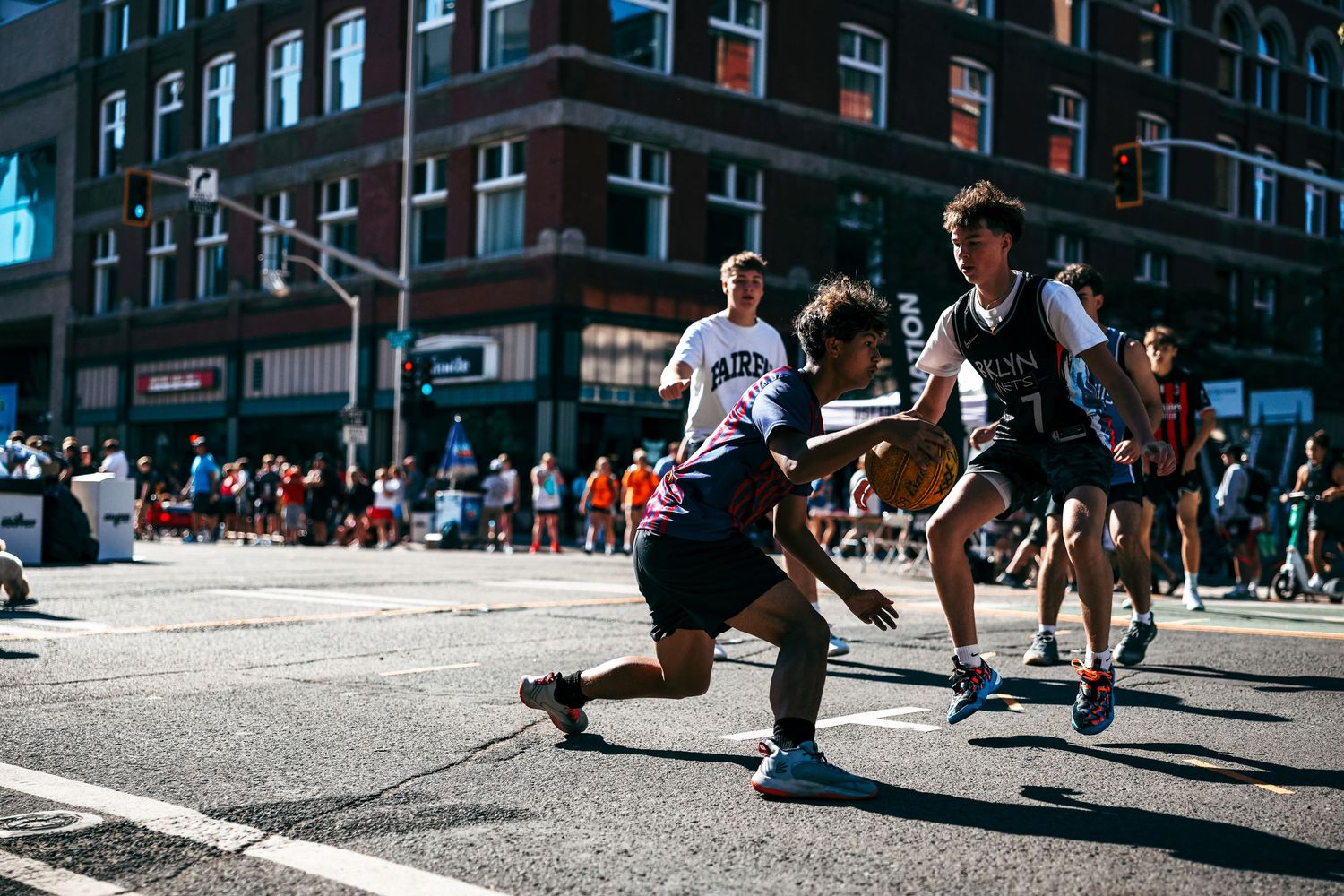 A sequence of five street photos showing people jumping and playing basketball on an urban sidewalk in sunlight.