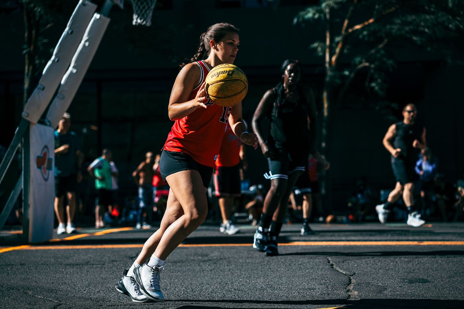 Woman playing basketball in the streets.