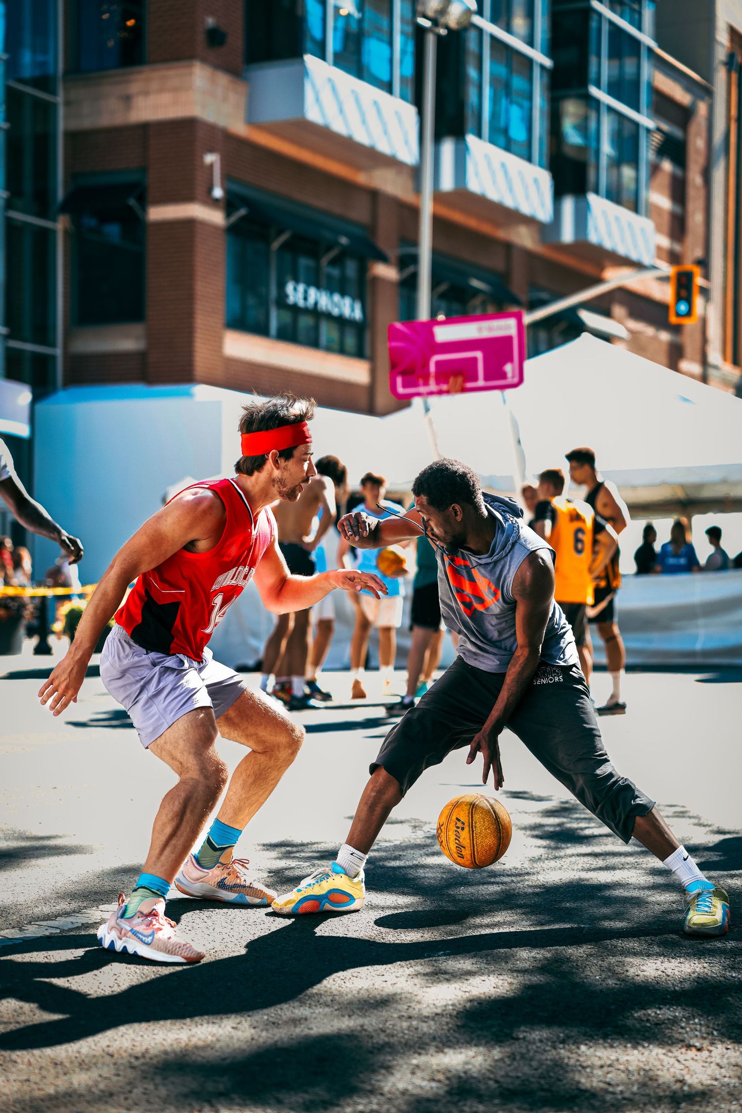 Basketball players dribble and compete for the ball on an urban street court in a dynamic sequence of action shots.