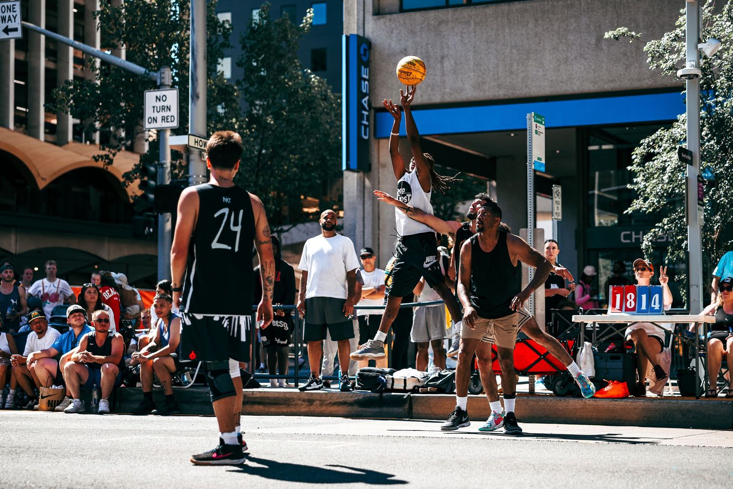 Basketball players in action on an outdoor court during a competitive street game.