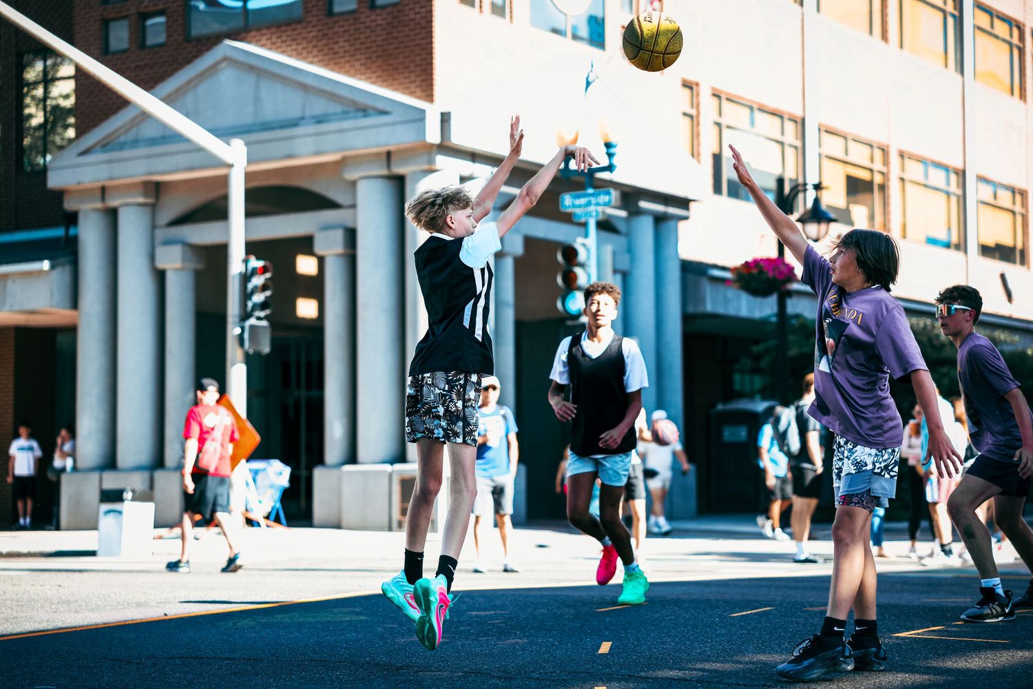A sequence of dynamic basketball action shots showing tricks and movements on an urban street.