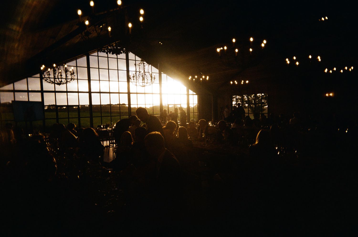 Botley Hill Barn, The Main Barn at sunset and it's beautiful floor to ceiling windows letting inlets of natural light.