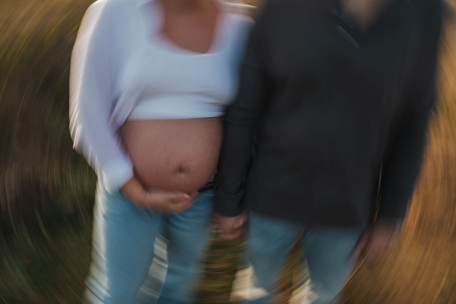 Blurred figures in casual clothing walking together at golden hour.