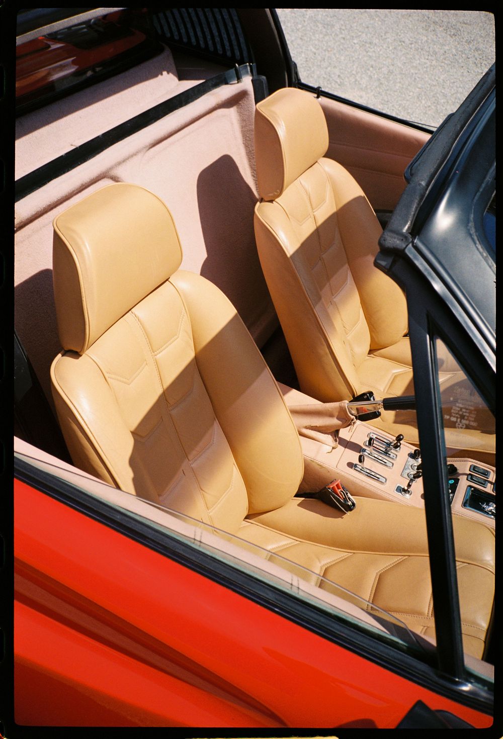 Vintage sports car interior featuring cream leather seats and classic dashboard details.