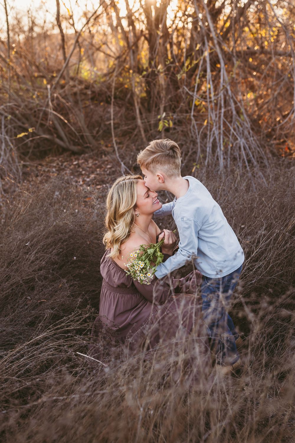 A tender moment shared between parent and child in a rustic outdoor setting during golden hour.