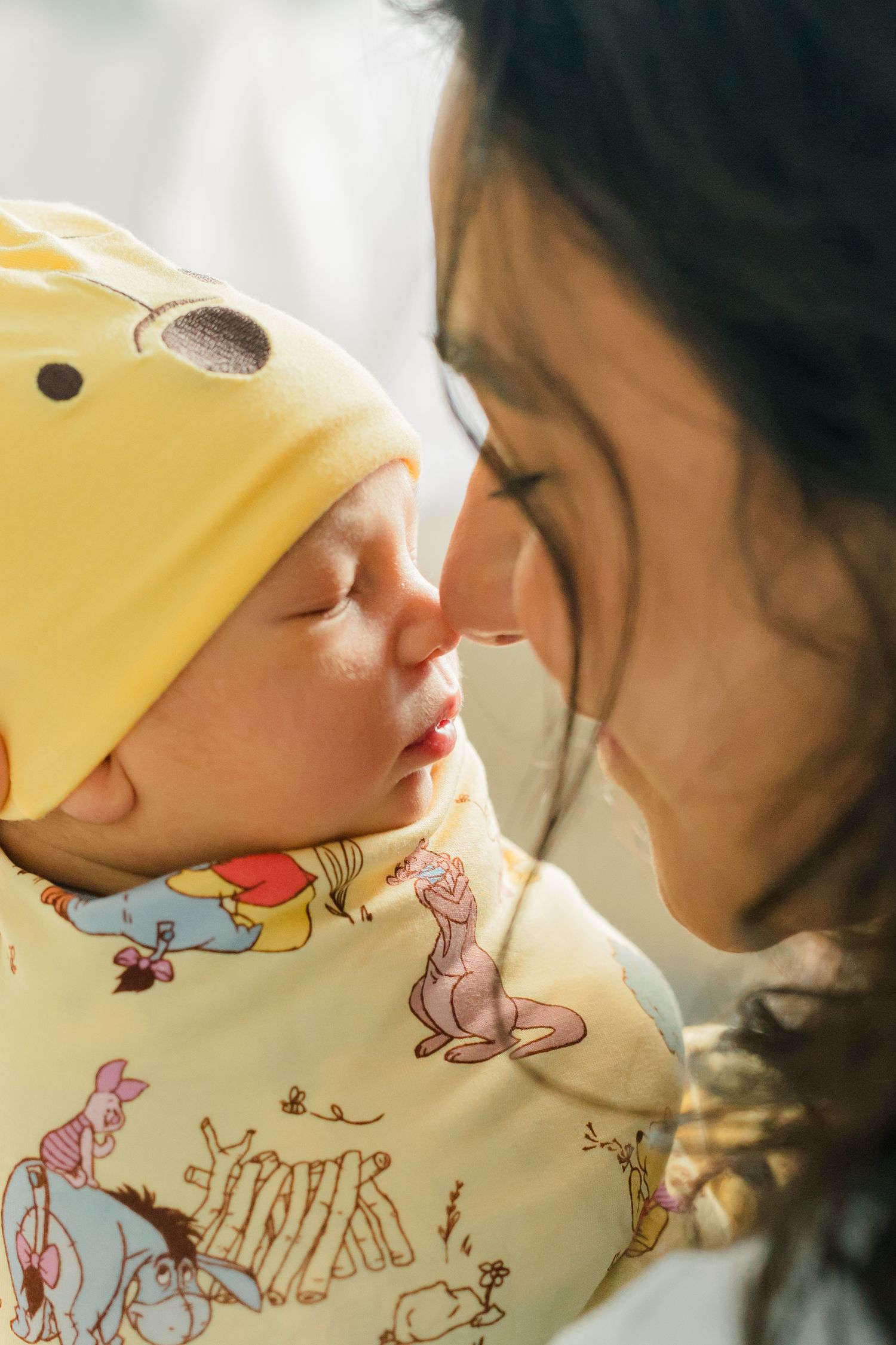 Two people share an intimate moment while one wears a yellow duck-themed hat with playful cartoon designs.