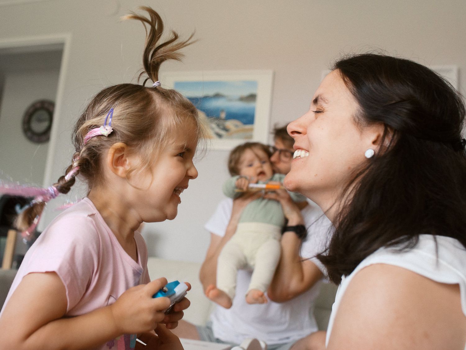 A joyful moment shared between family members at home with a playful interaction in the background.