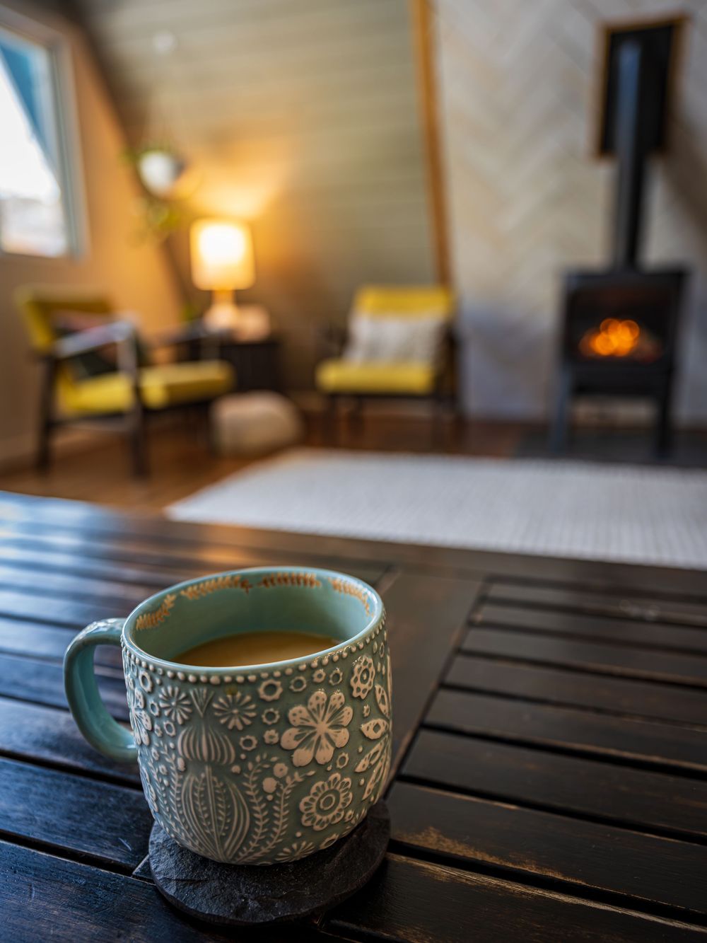 Coffee mug in front of a fireplace at the Hygge Chalet by Denver Hospitality, Travel & Tourism photographer Captain Colorado Photography.
