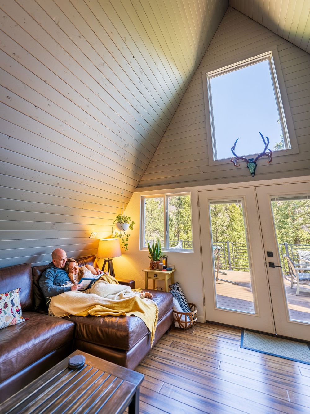 A couple cuddling on a couch at the Hygge Chalet by Denver Hospitality, Travel & Tourism photographer Captain Colorado Photography.