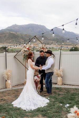 Bride and groom exchanging vows during a backyard wedding ceremony in Utah